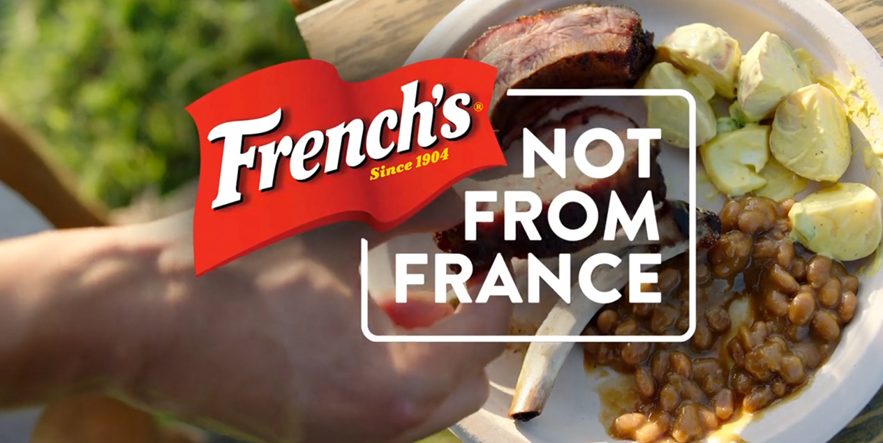 Potato salad, beans and ribs behind French's logo