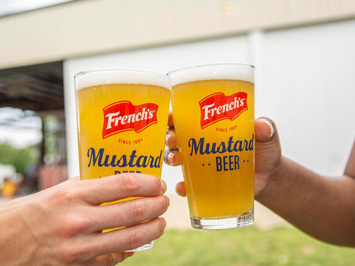 Two people toasting a French's Mustard beer
