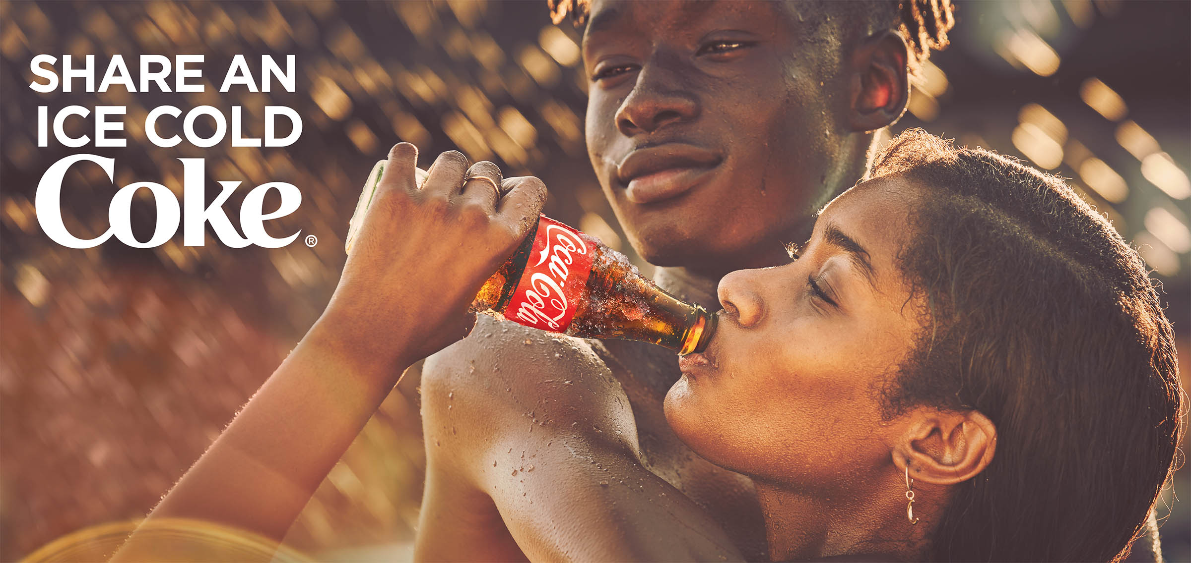 Billboard of teens with Coca-Cola. Says "Share an ice cold Coke".